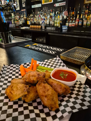 Broaster chicken wings with celery, carrots, and dipping sauce